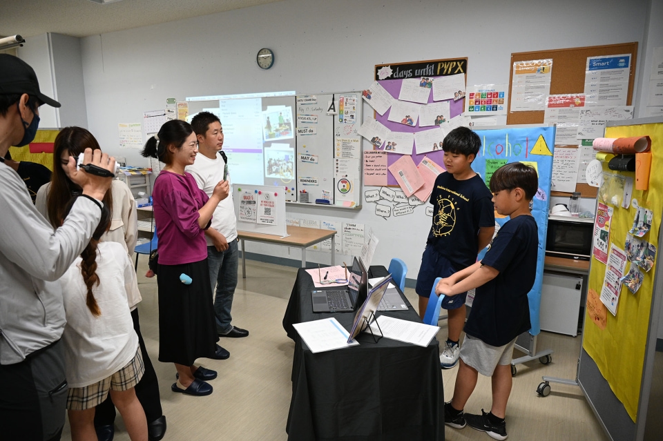 Students presenting a classroom project to a small group of adults and peers.